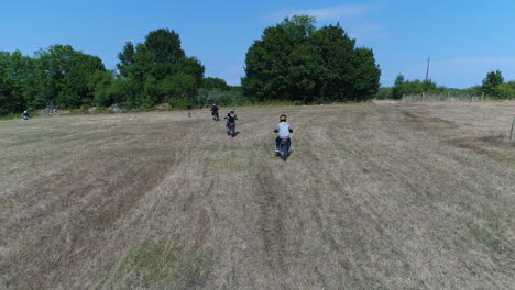 Vista-Aérea-De-Drones-De-Niños-Montando-Bicicletas-De-Cross-En-Un-Campo.-Ubicación-Francia